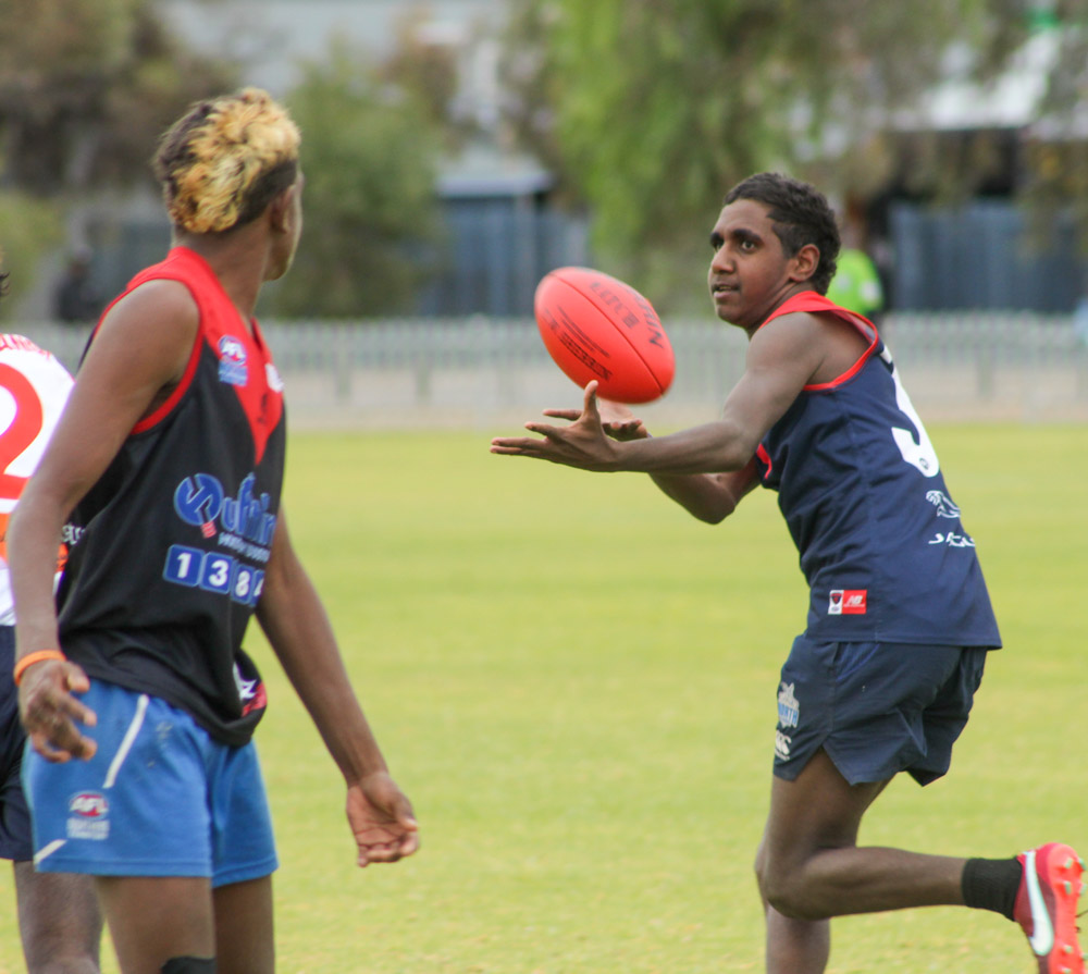 Ti Tree Roosters player receiving a handball.