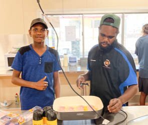 Jacob Turner and Zacc Stafford (YSR officer) cooking some bacon.