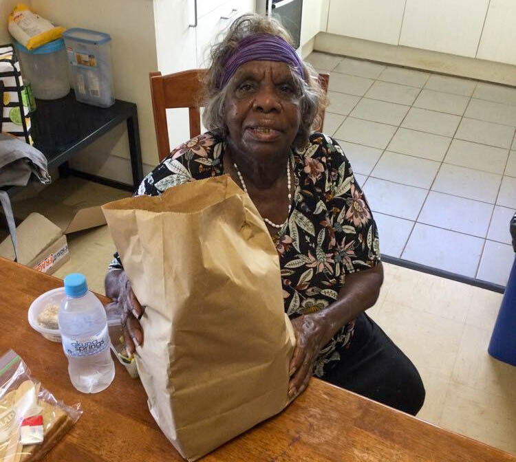 Eileen Campbell receiving a food hamper pack in Anmatjere to celebrate Elders.
