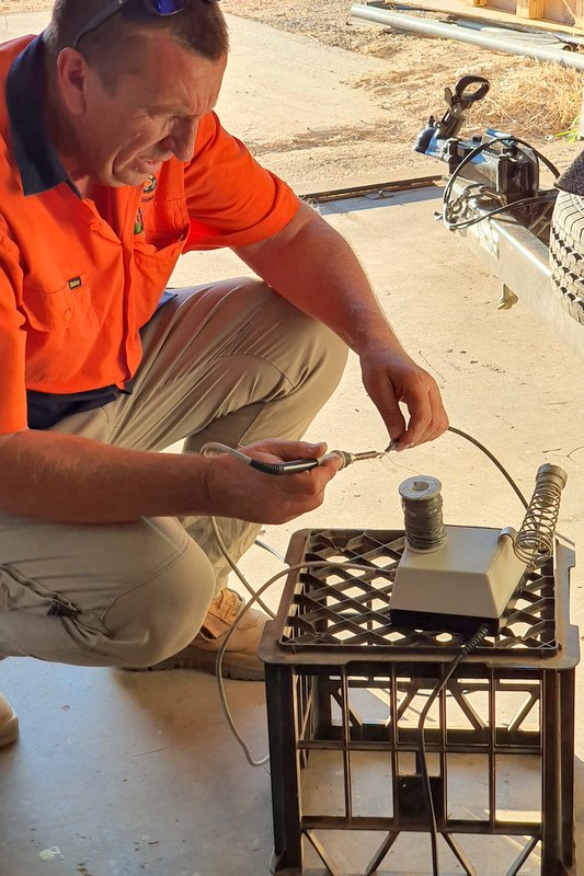 Warren Kenney working on the electronics of the Atitjere barbecue trailer