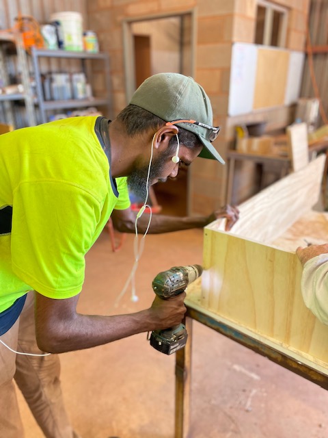 Freddy Patrick putting together a book shelf.