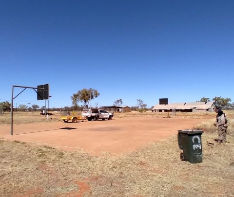 Brush cutting the grass around the basketball court